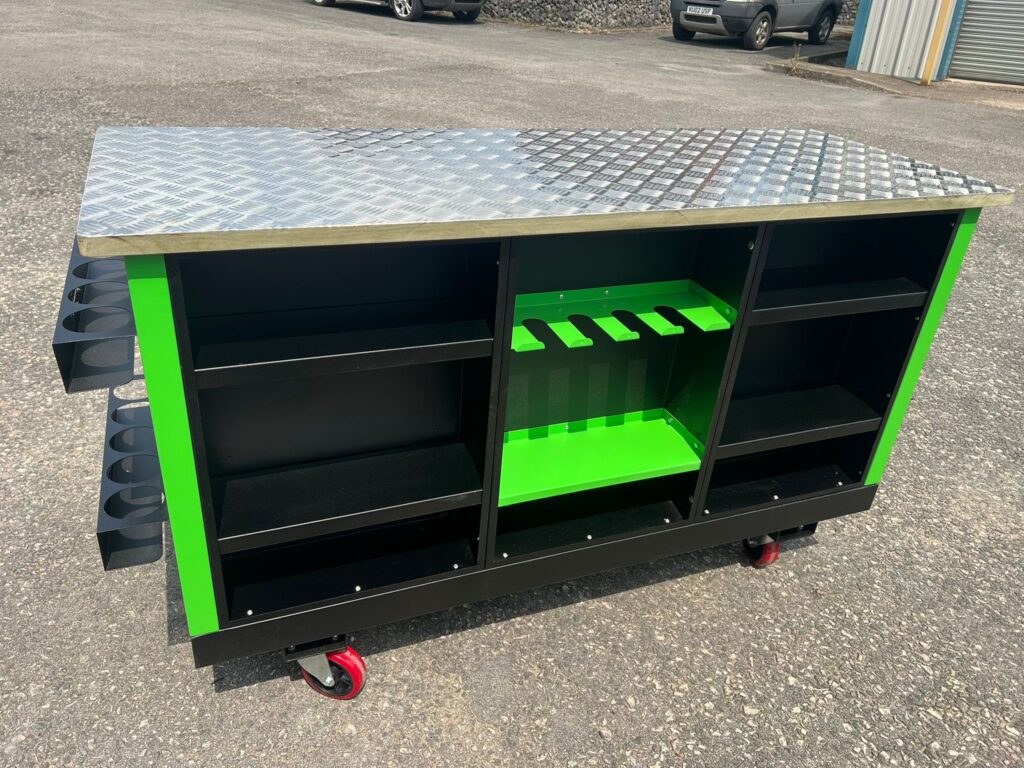 Custom green and black workshop unit with diamond‑plate top and mobile caster wheels