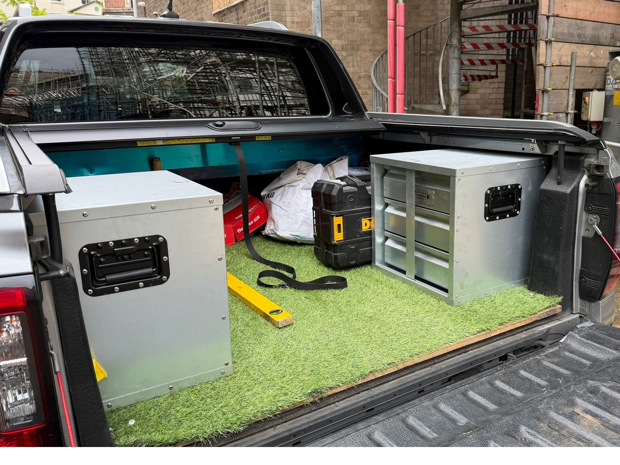 Pickup truck bed with metal van storage boxes, DeWalt toolbox and tools organised for mobile work