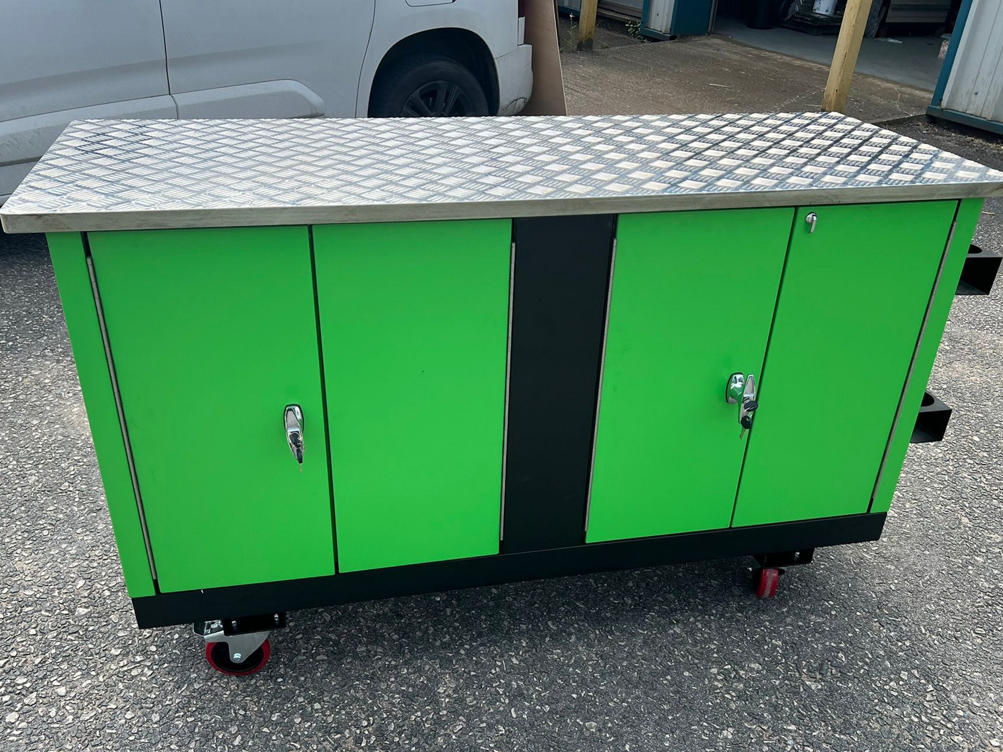 Green and black workshop cabinet with four locking doors and diamond‑plate stainless steel top