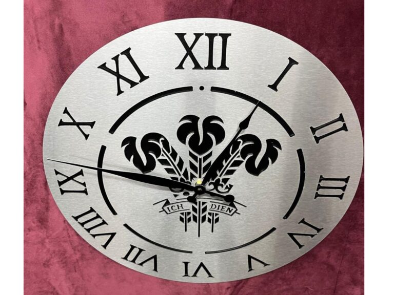 Metal wall clock with Prince of Wales feathers emblem and Roman numerals