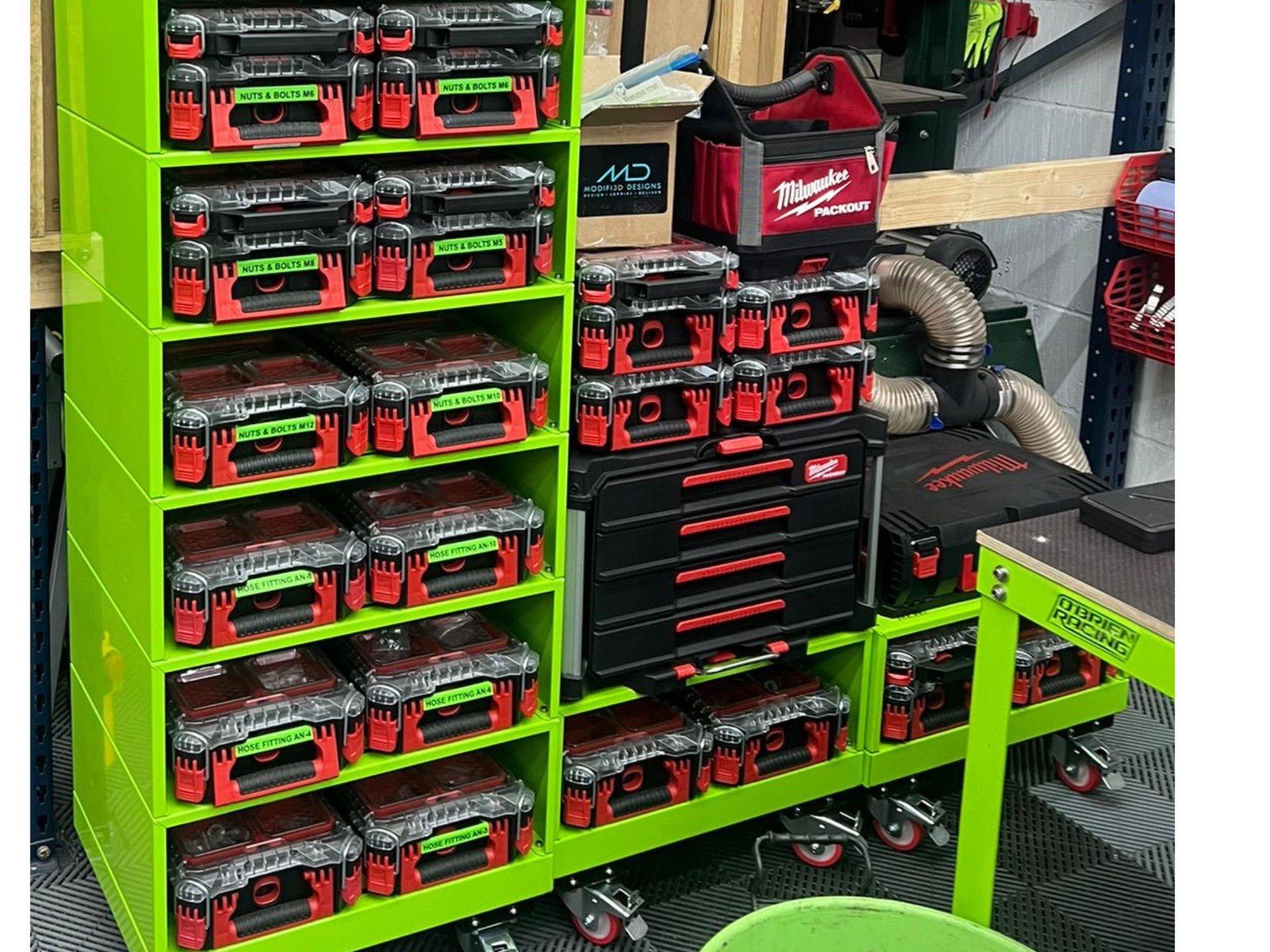 Motorsport workshop shelving with Milwaukee Packout tool boxes and labelled hardware containers